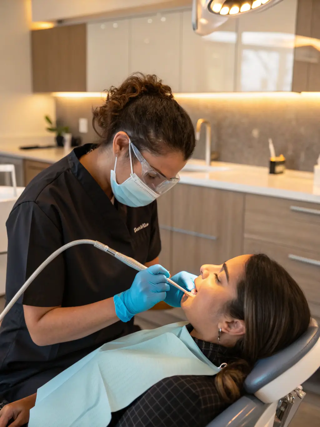 A close-up, high-resolution photograph of a dentist using scaling and root planing tools to clean a patient's teeth, illustrating the initial stage of periodontal treatment at Apolon Dent.